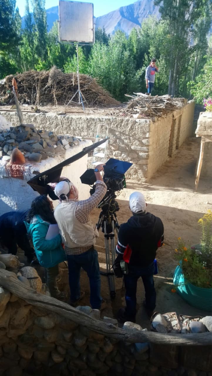 High-angle view of the camera crew and cinematographer Arvind Kannabiran framing a shot in a village lane