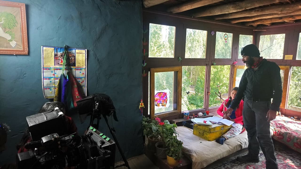 Production crew arranging lighting and camera angles for a bedroom scene with Jigmet Dewa Lhamo by a window